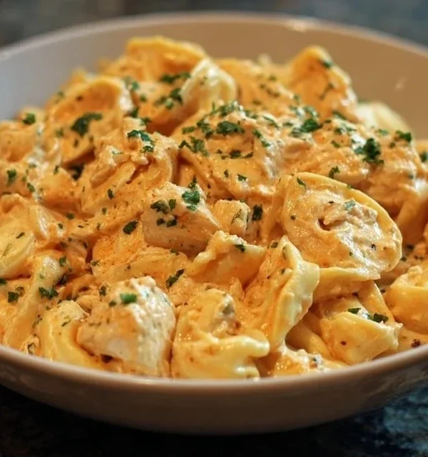 A bowl of easy Crockpot Chicken Tortellini with vegetables and herbs