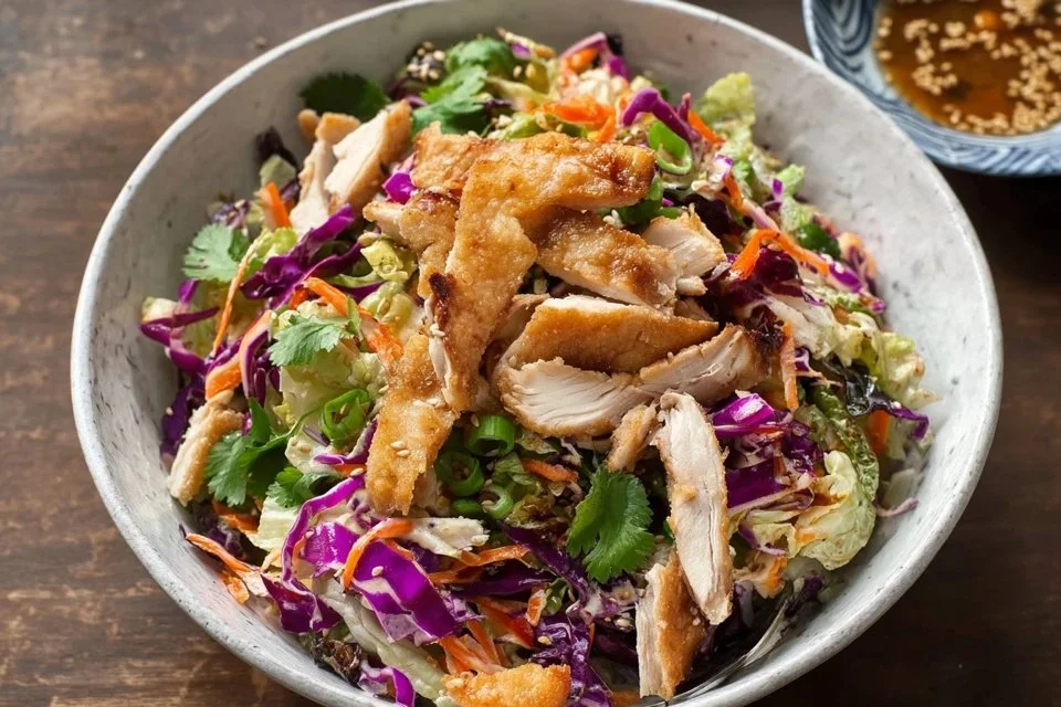 Bowl of healthy Asian chicken salad with colorful vegetables and grilled chicken